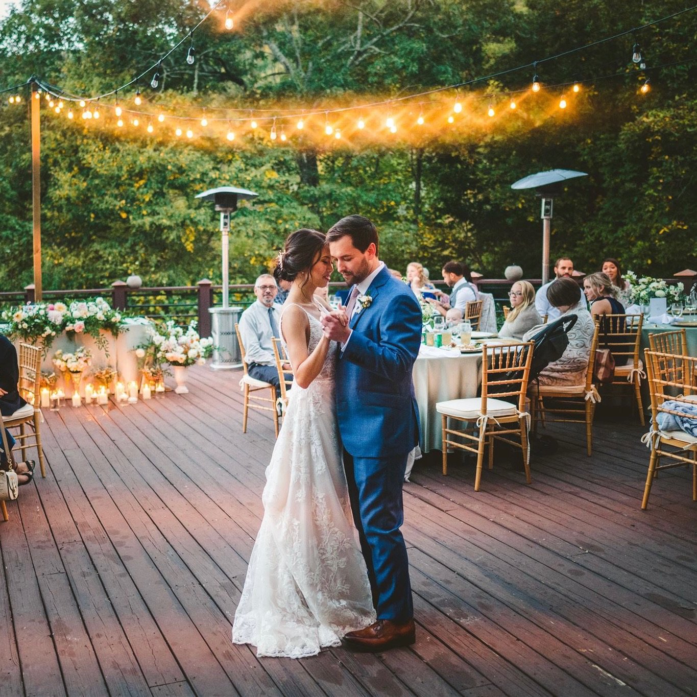 Bride and Groom dance together on porch under string lights