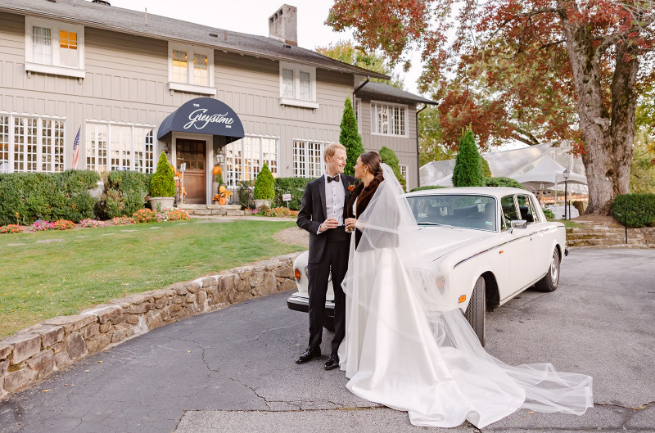Bride and groom with vintage car at mountain wedding venue